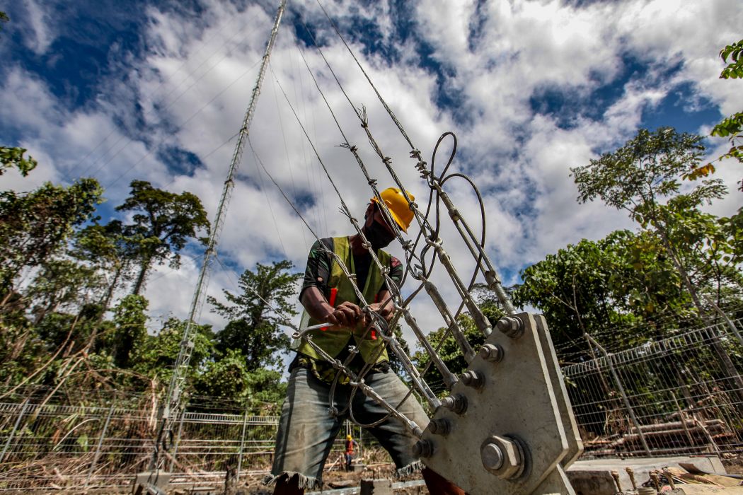 Pekerja menyelesaikan pembangunan Base Transceiver Station (BTS) di Kampung Malagufuk, Distrik Makbon, Kabupaten Sorong, Papua Barat, Jumat (23/7/2021). 