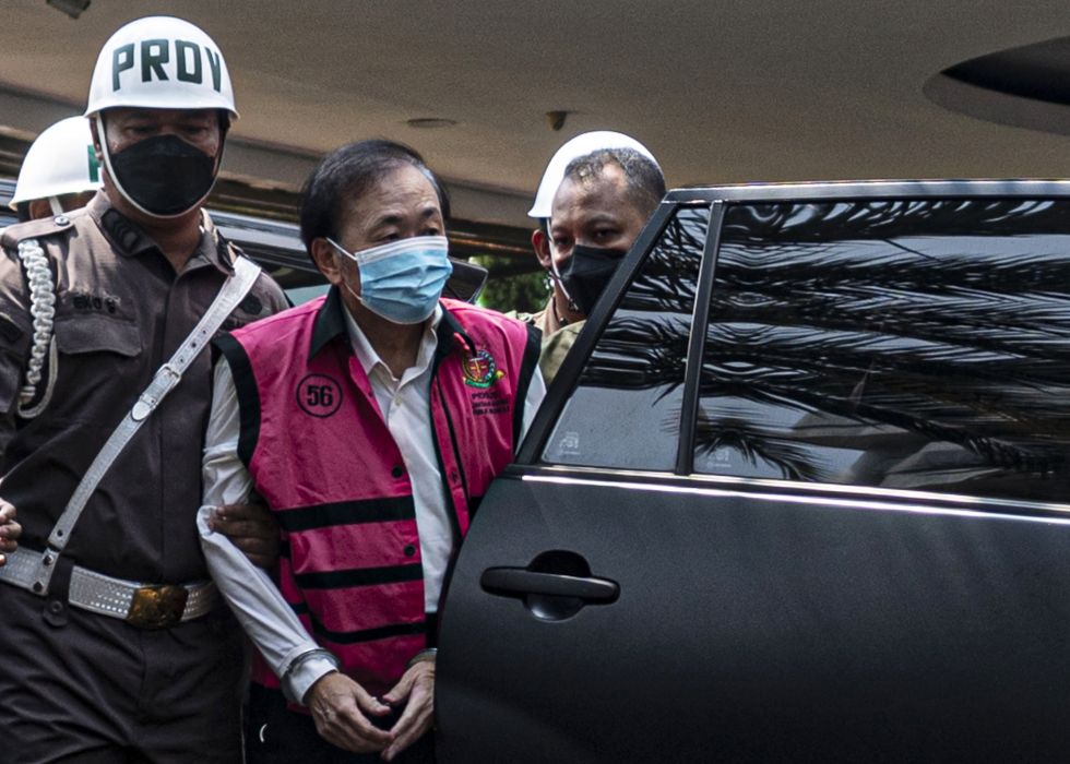  Petugas Kejaksaan Agung mengawal tersangka kasus dugaan korupsi Surya Darmadi (tengah) saat tiba untuk menjalani pemeriksaan di Gedung Kejaksaan Agung, Jakarta, Kamis (18/8/2022).