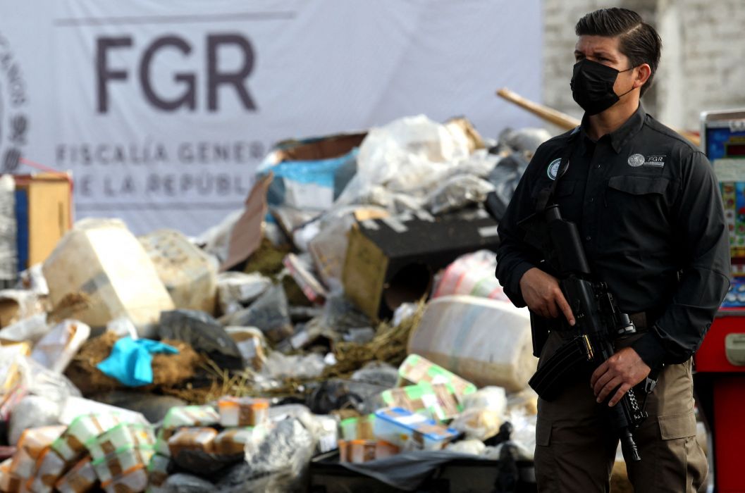 Seorang petugas dari Kejaksaan Agung berjaga di depan pembakaran satu ton 965 kilogram narkoba yang disita di Zapopan, Negara Bagian Jalisco, Meksiko, pada 14 Juli 2022.