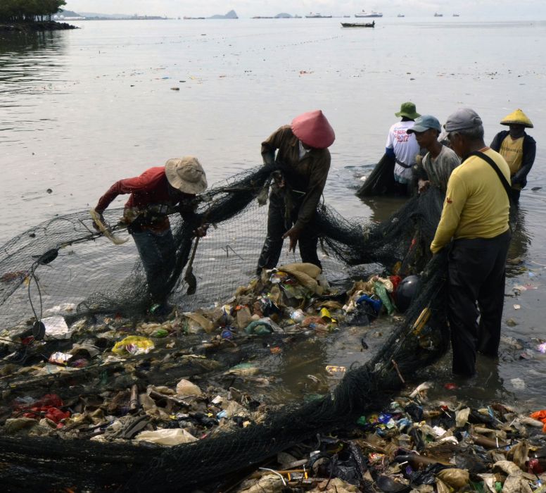 Nelayan membersihkan sampah termasuk sampah plastik yang tersangkut di jaring saat melaut di Pantai Sukaraja, Bandar Lampung, Lampung, Selasa (25/10/2022)
