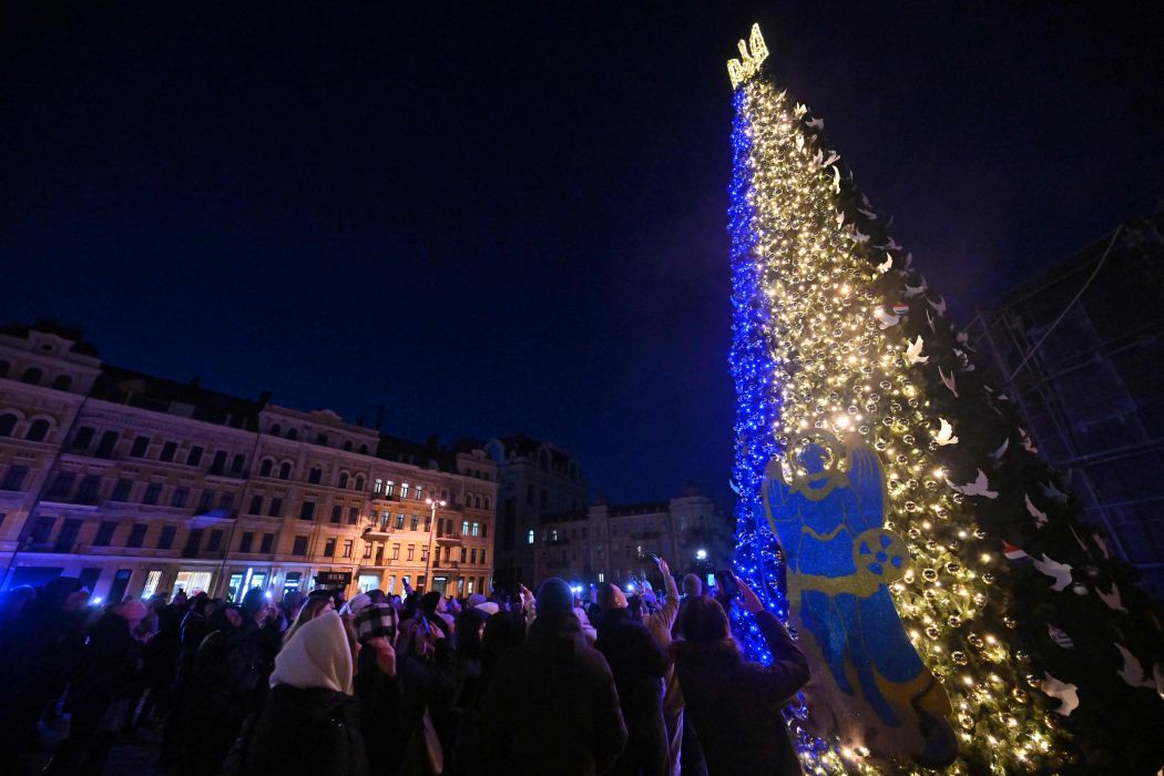 Masyarakat berfoto selfie saat upacara pembukaan pohon Natal utama Kyiv di Lapangan St. Sophia di ibu kota Ukraina, Kyiv, Senin (19/12/2022).