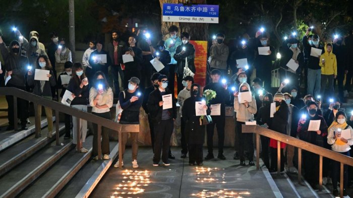 Para demonstran anti-pembatasan sosial Covid-19 berunjuk rasa dengan bawa lembar kertas kosong di Jalan Urumuqi, Guangzhou, Tiongkok, Rabu (30/11).  