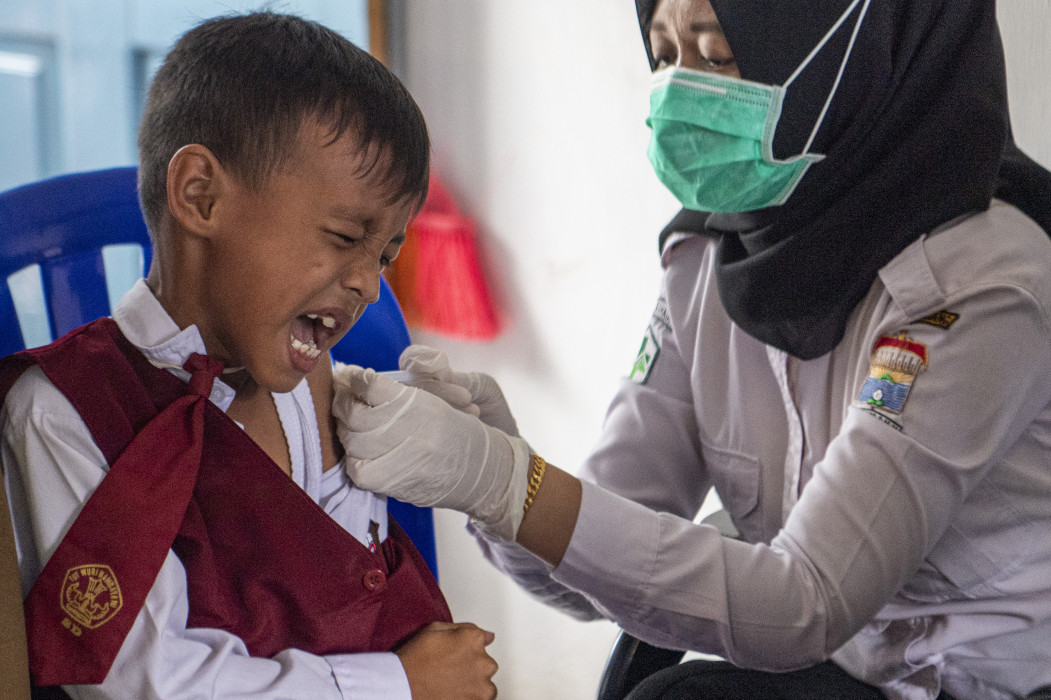 Petugas kesehatan dari Puskesmas Kampus Palembang menyuntikkan vaksin difteri dan tetanus kepada siswa saat kegiatan Bulan Imunisasi Anak Sekolah (BIAS) di SD Negeri 21 Palembang, Sumsel,  Senin (21/11/2022).