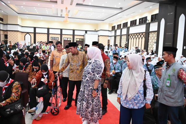 Ketua Komisi VIII DPR RI Ashabul Kahfi menyapa sejumlah jemaah haji saat melepas  kloter pertama CJH dari Embarkasi Makassar, Sulawesi Selatan. 