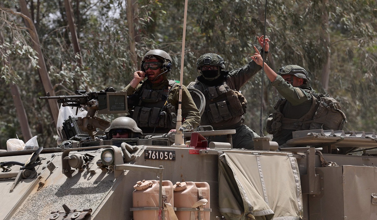 Personel militer Israel menumpang tank di Jalur Gaza.
