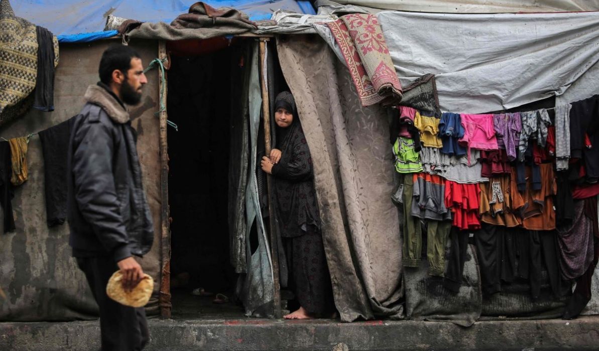 Seorang pria Palestina dan seorang wanita berdiri di pintu tenda di kawasan perumahan pengungsi, Rafah, Palestina.