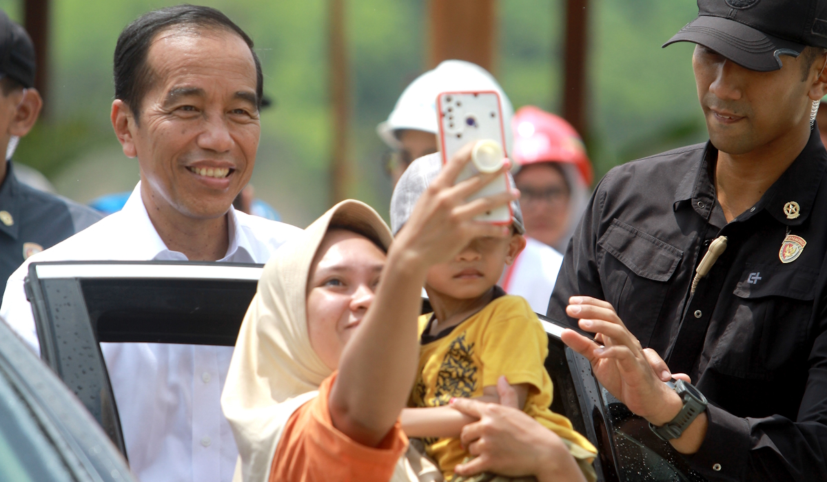Presiden Joko Widodo (kiri) memenuhi permintaan warga untuk berswafoto 