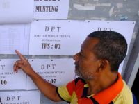 Warga mencari namanya pada papan pengumuman daftar pemilih tetap (DPT) Pemilu 2024 di Balai Desa Muntung, Candiroto, Temanggung, Jawa Tengah