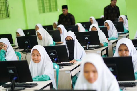 Santriwati mengikuti ujian akhir semester berbasis komputer di Pondok Pesantren Assalam Naga Beralih, Kampar, Riau
