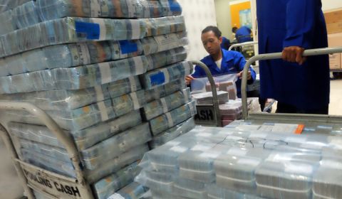 Petugas memindahkan tumpukan uang tunai di Pooling Cash Plaza Mandiri, Jakarta Selatan 