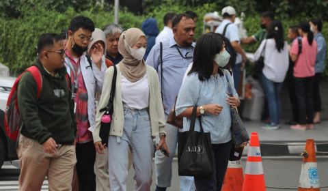 Pekerja berjalan menuju kantornya di pedestrian kawasan Sudirman, Jakarta, Rabu 